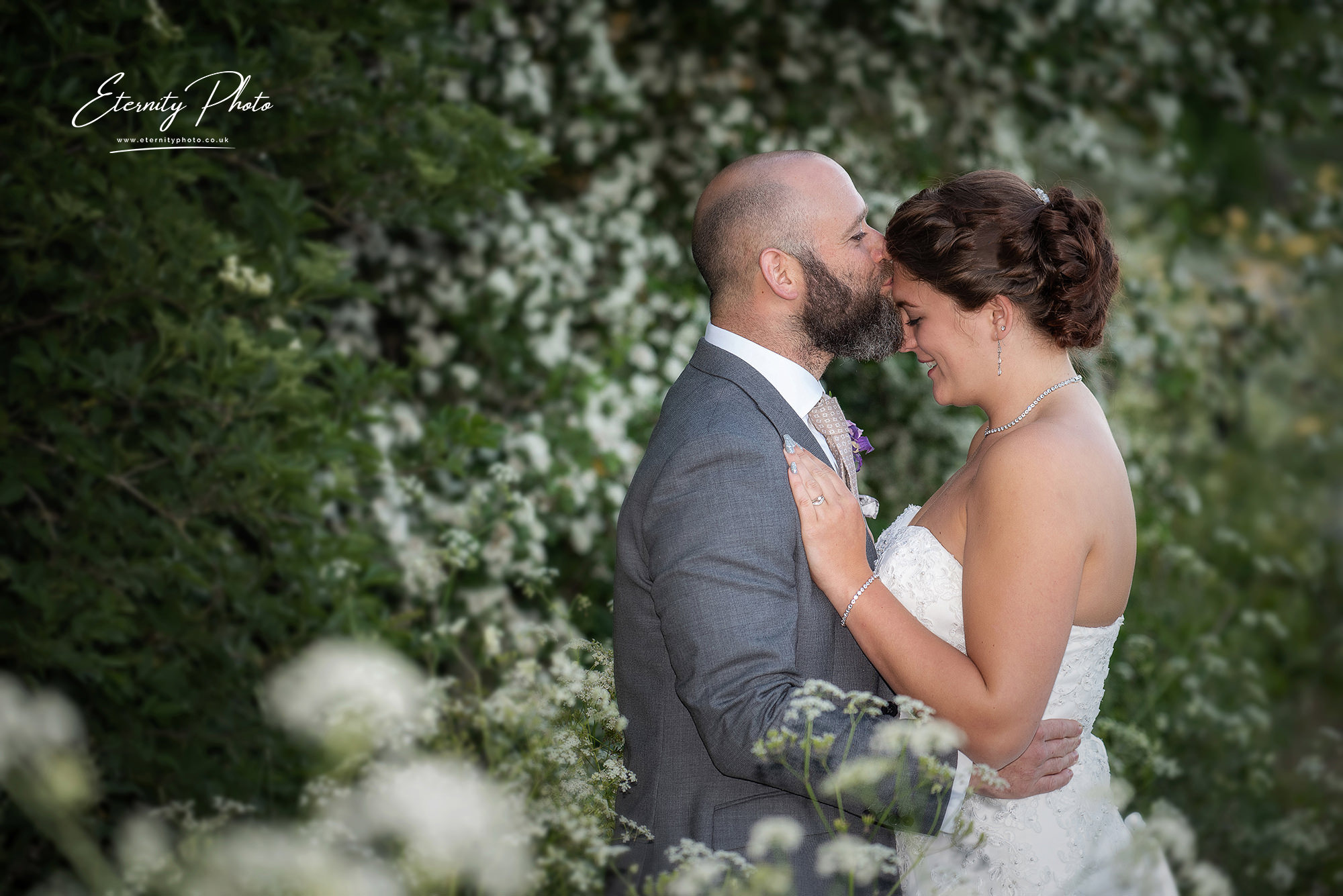 Couple embracing at a floral outdoor wedding.