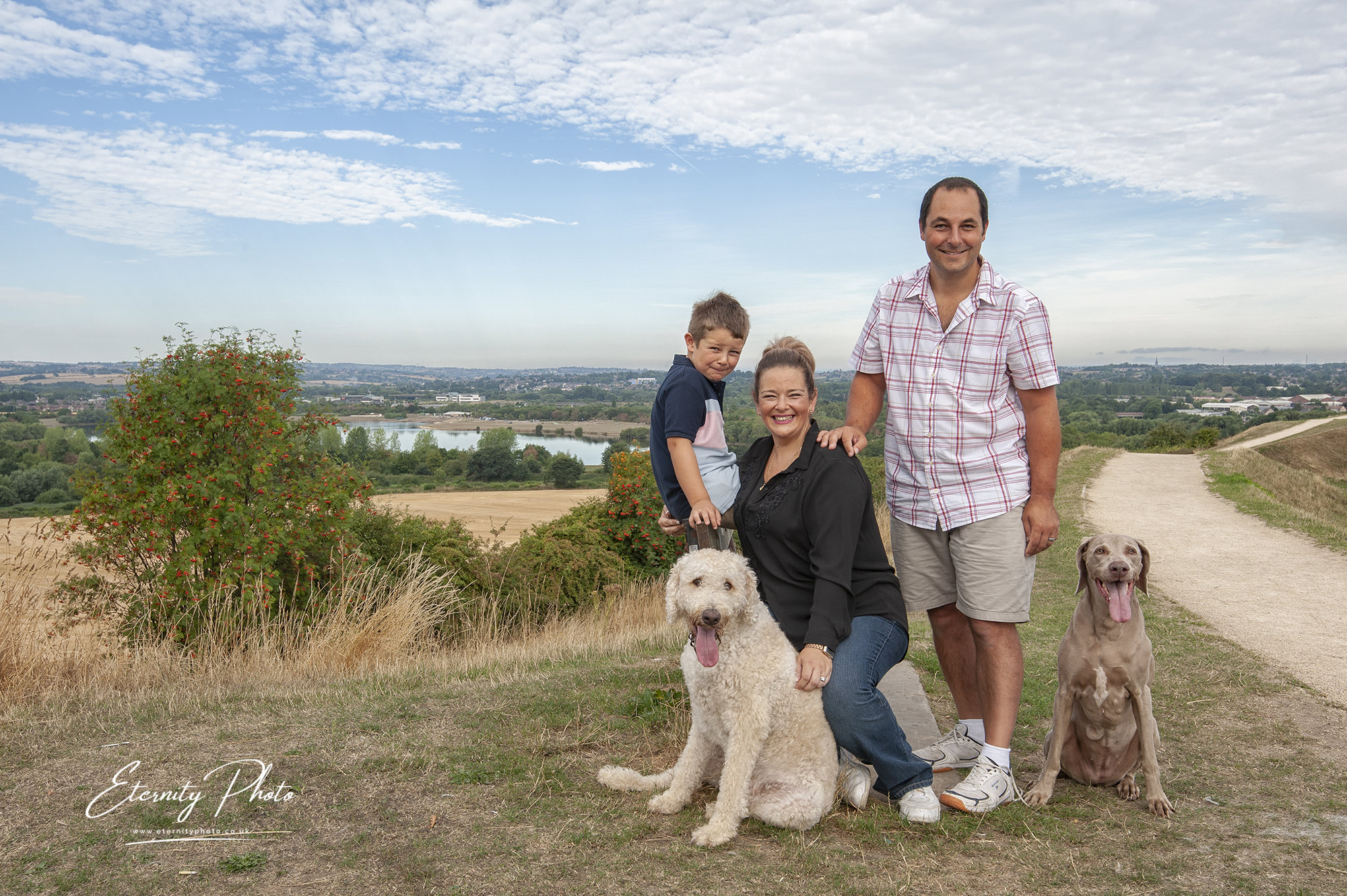 Family and dogs enjoying countryside panorama.