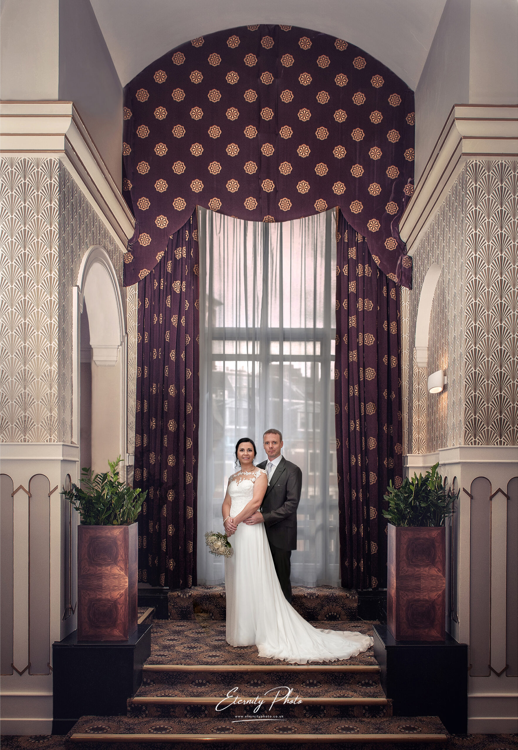 Bride and groom posing in elegant vintage-style interior.