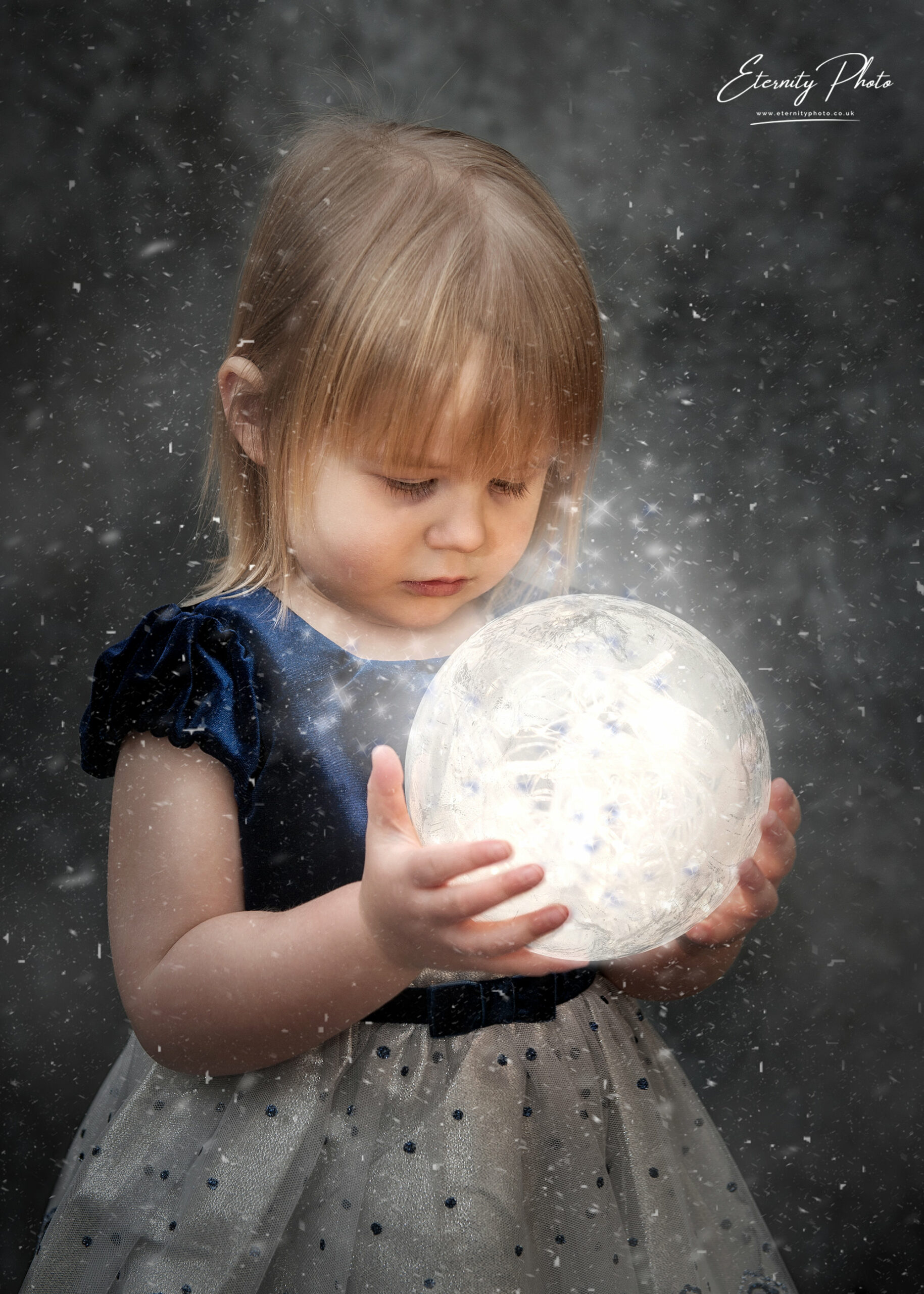 Child holding glowing orb in snow.