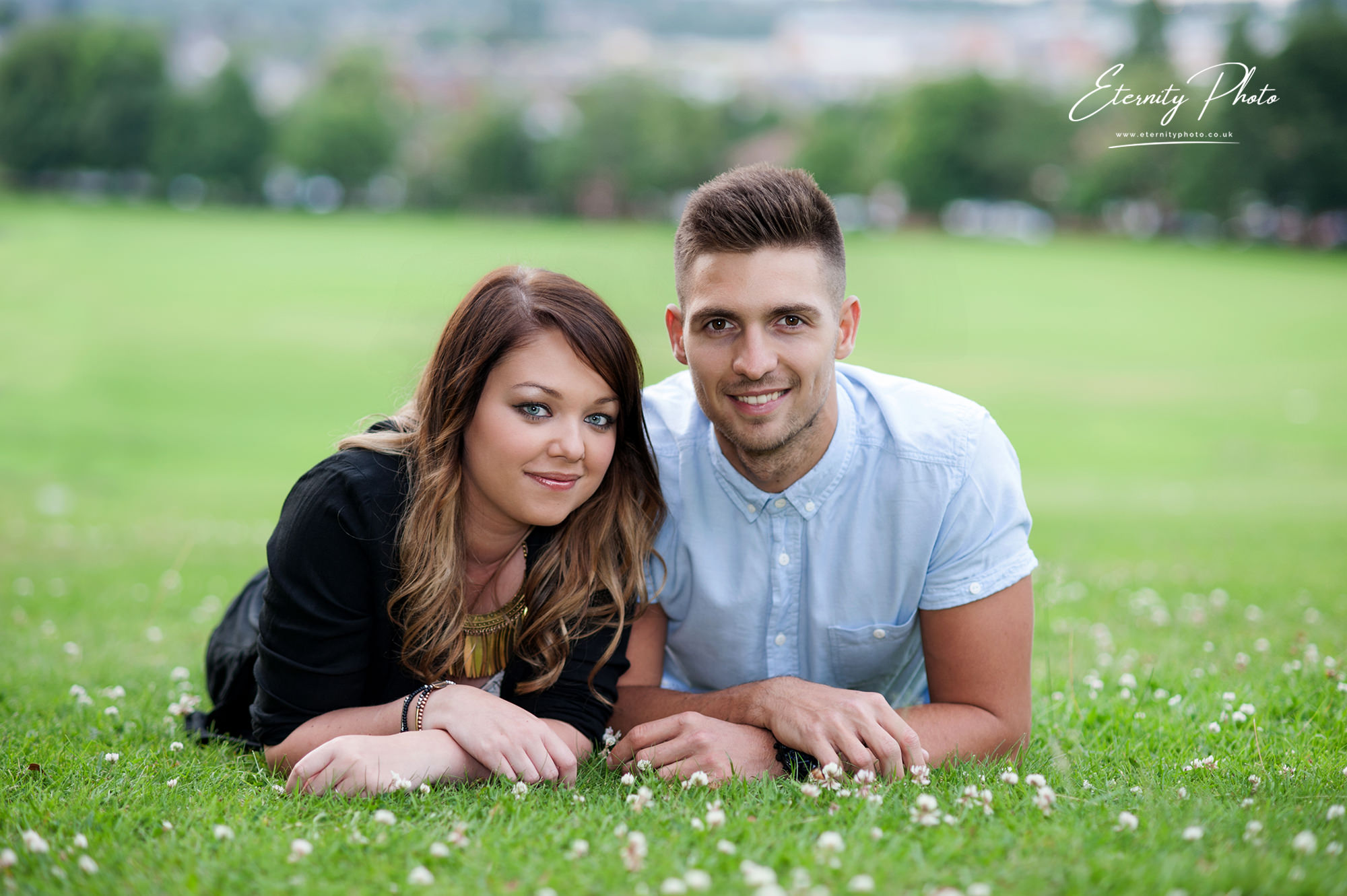 Couple lying on grass in a park.