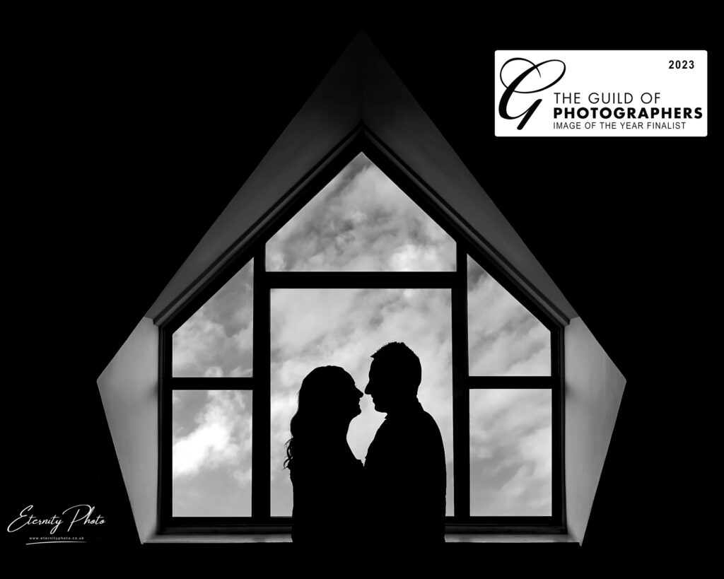 Silhouetted couple in triangular window frame