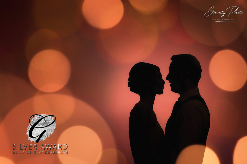 Silhouetted couple with bokeh lights, award-winning photography.